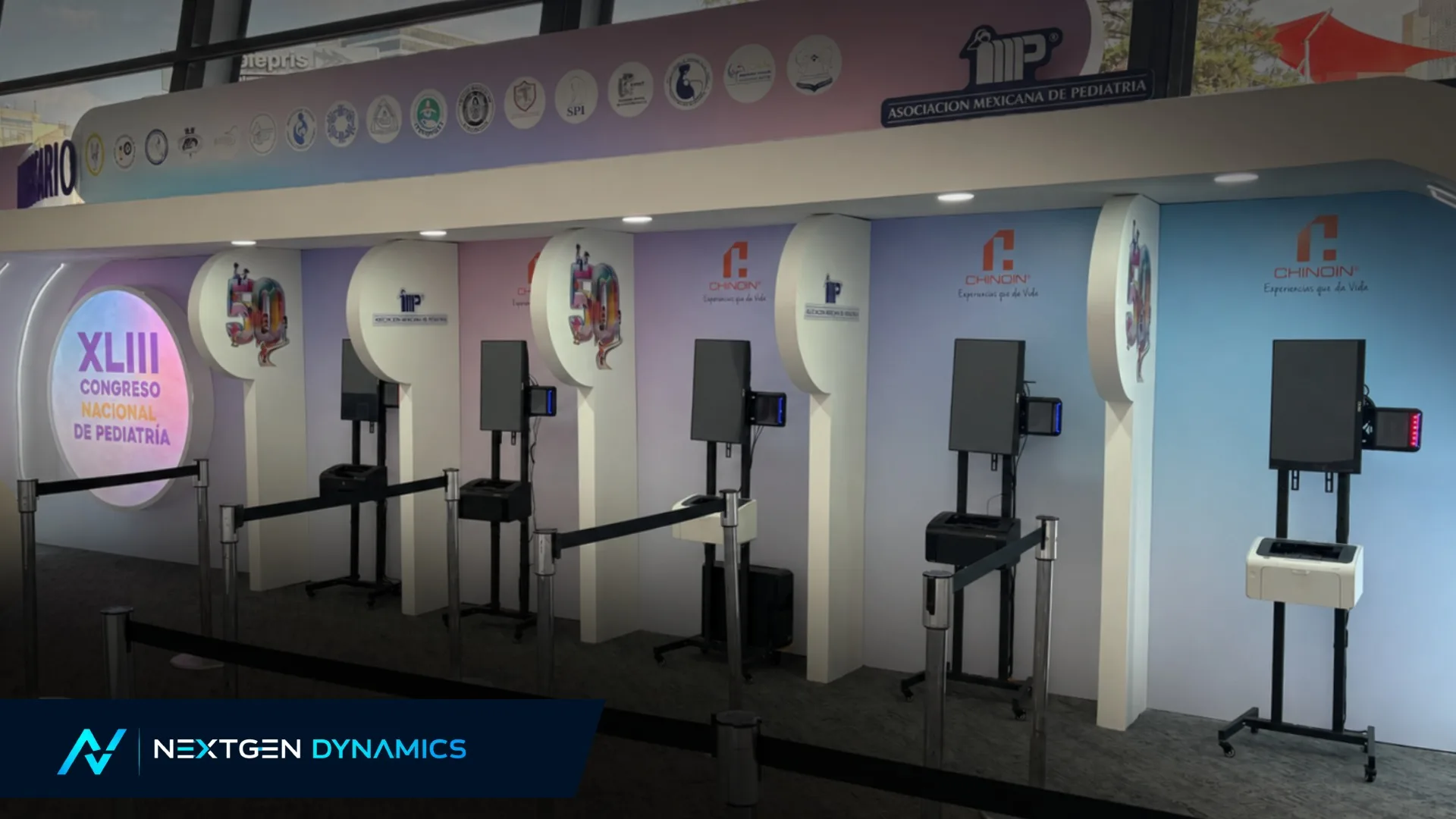 Fila de kioskos NXD de autoservicio con impresoras de gafetes